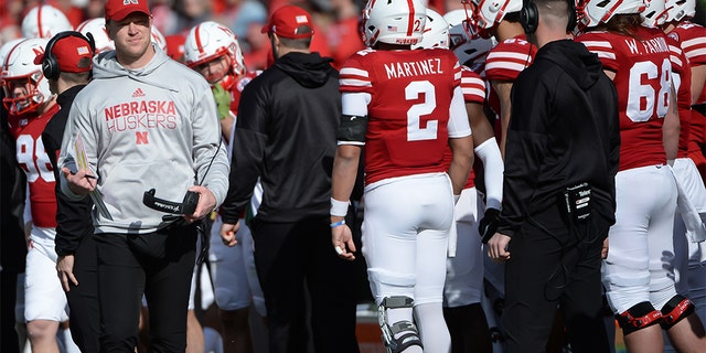 Head coach Scott Frost of the Nebraska Cornhuskers greets quarterback Adrian Martinez #2 after a series of plays against the Wisconsin Badgers at Memorial Stadium on November 16, 2019 in Lincoln, Nebraska.