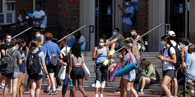 University of North Carolina students wait outside of Woolen Gym on the Chapel Hill, N.C., campus as they wait to enter for a fitness class Monday, Aug. 17, 2020. 
