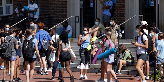 University of North Carolina students wait outside of Woolen Gym on the Chapel Hill, N.C., campus as they wait to enter for a fitness class Monday, Aug. 17, 2020. 