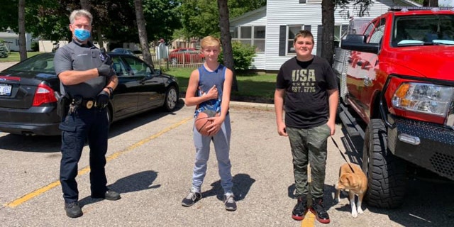 The Wayland Police Department made Austin Nichols, 13, and Logan Mishoe, 14, holding dog, honorary "Citizens of the Day" after finding a cash-filled wallet in a park and turning it in to an officer.