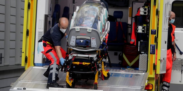 An empty stretcher is carried back into an ambulance that is believed to have transported Alexei Navalny at the emergency entrance of the Charite hospital in Berlin, Germany, on Saturday. (AP)