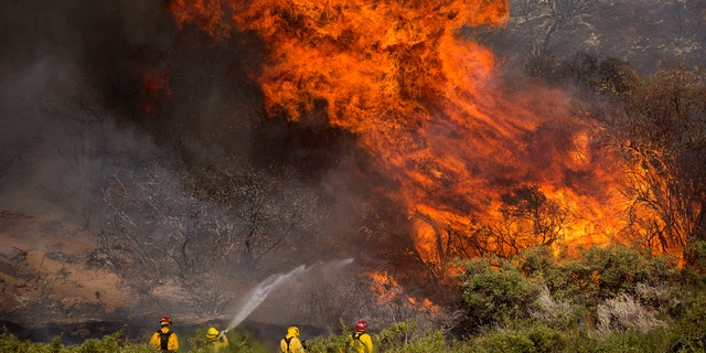 Firefighters work against the Apple Fire near Banning, Calif., Sunday, Aug. 2, 2020.