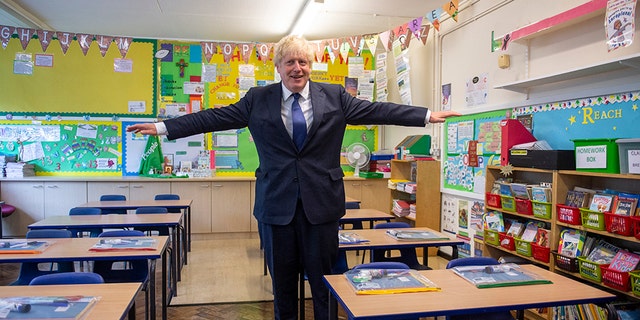 FILE - In this Aug. 10, 2020, file photo, Britain's Prime Minister Boris Johnson visits St Joseph's Catholic Primary School, London, to see the steps they are taking to be COVID-secure ahead of children returning in September. Britain’s prime minister is asking parents to set aside their fears and send their children back to school next month when the nation’s schools fully reopen for the first time since the coronavirus pandemic shut then down more than five months ago. Johnson said it was the government’s "moral duty’’ to reopen the schools as he stressed that authorities now know more about COVID-19 than they did when the country went into lockdown on March 23. (Lucy Young/Pool via AP, File)