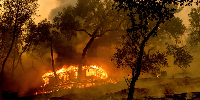 As chamas consomem uma cabana na vinícola da família Nichelini, no condado não incorporado de Napa, enquanto o incêndio de Hennessey arde na terça-feira, 18 de agosto de 2020.