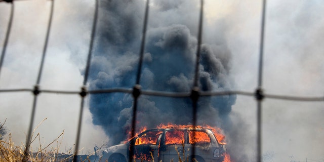 A brush fire burns a car at the Apple Fire in Cherry Valley, Calif., Saturday, Aug. 1, 2020.