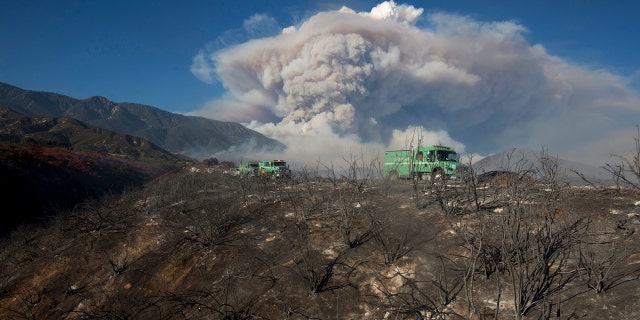 Some rises behind an area burned by a brush fire at the Apple Fire in Cherry Valley, Calif., Saturday, Aug. 1, 2020.