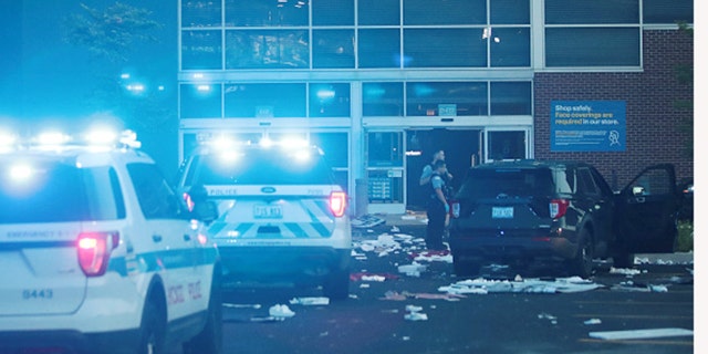 Police officers inspect a damaged Best Buy store in Chicago after parts of the city suffered widespread looting and vandalism. (Getty Images)