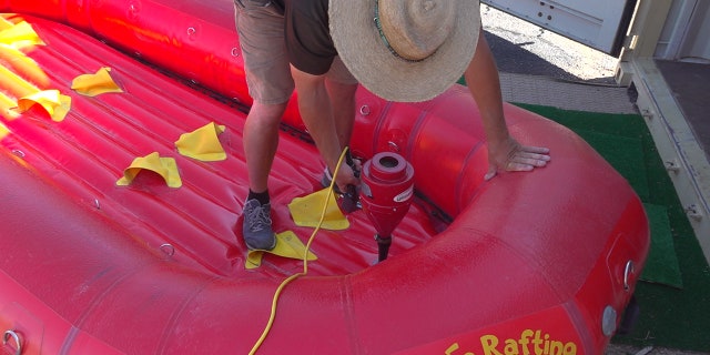 Santa Fe Rafting Co. owner Jared McClure prepares rafts for the next trip. They clean all equipment and set it aside for 24-48 hours before the next use.
