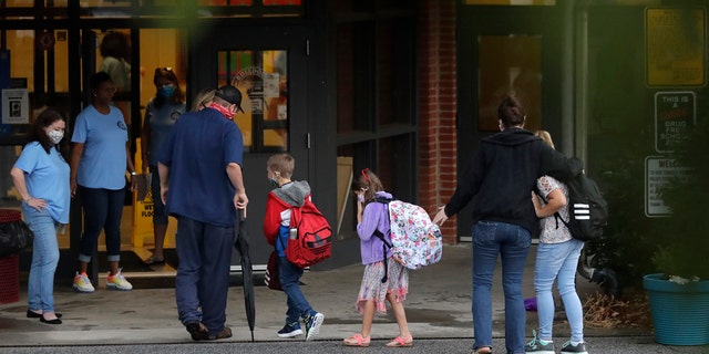 Students arrive at Dallas Elementary School in Dallas, Ga., for the first day of the 2020-21 school year amid the coronavirus outbreak. (AP Photo/Brynn Anderson)