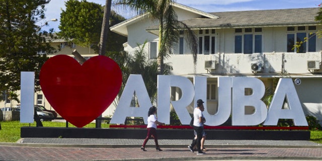Tourists walk along a street in Oranjestad, Aruba on August 27, 2013. 