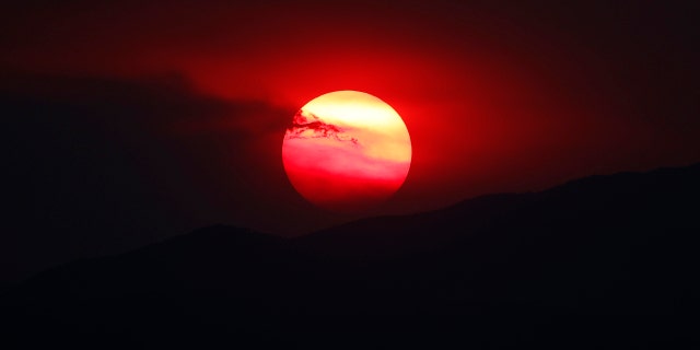As wildfires burn throughout the Western Slope, the sun sets a bright orange behind the Rocky Mountains for residents of the eastern plains Wednesday, Aug. 12, 2020, in Denver.