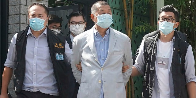 Lai, center, is arrested by police officers at his home in Hong Kong on Monday. (AP Photo)