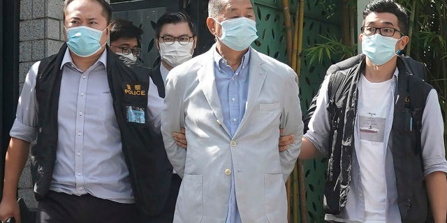 Lai, center, is arrested by police officers at his home in Hong Kong on Monday. (AP Photo)