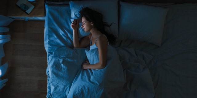 Woman sleeping in her bedroom at night.