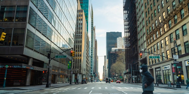 New York, NY, USA - April 6, 2020: A man wearing protective mask crosses 6th Avenue of Americas in Midtown Manhattan deserted because of the city lockdown caused by COVID-19 pandemic. (iStock)