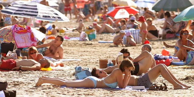 Beachgoers sunbathe at Cap d'Agde, France along the Mediterranean Sea.