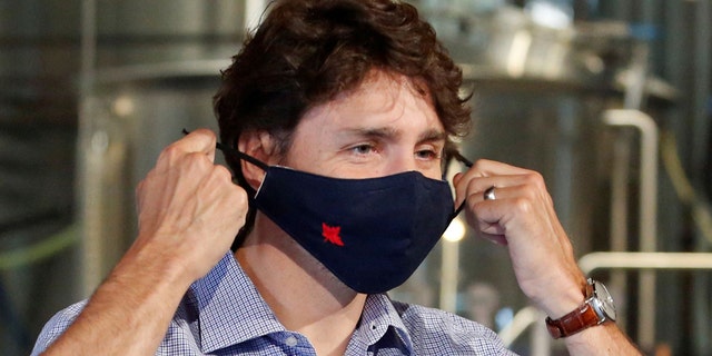 Canada's Prime Minister Justin Trudeau removes his face mask as he visits the Big Rig Brewery in Kanata, Ontario, Canada, on June 26, 2020. (REUTERS/Patrick Doyle)