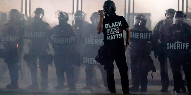 People gather Tuesday, Aug. 25, 2020 to protest in Kenosha, Wis. Anger over the Sunday shooting of Jacob Blake, a Black man, by police spilled into the streets for a third night. 