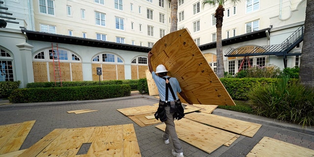 Workers board up windows at the Galvez Hotel & Spa Tuesday, Aug. 25, 2020, in Galveston, Texas, as Hurricane Laura heads toward the Gulf Coast.