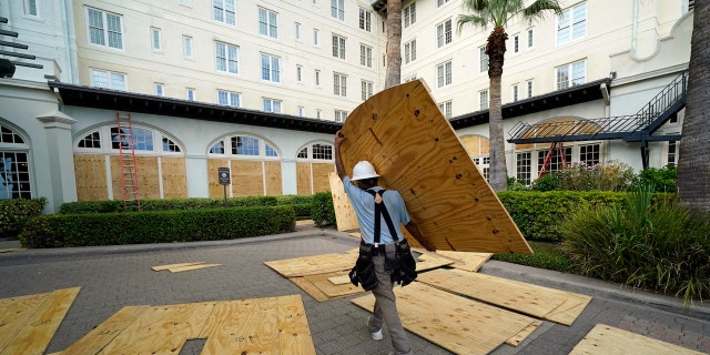 Workers board up windows at the Galvez Hotel & Spa Tuesday, Aug. 25, 2020, in Galveston, Texas, as Hurricane Laura heads toward the Gulf Coast.