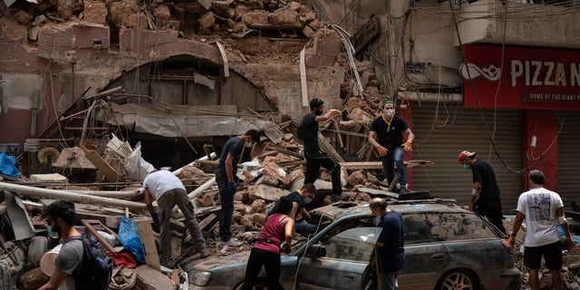 People remove debris from a house damaged by Tuesday's explosion in the seaport of Beirut, Lebanon, on Aug. 7. (AP)