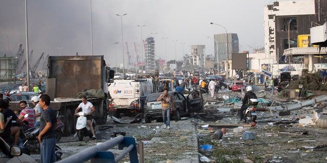 People evacuate wounded after of a massive explosion in Beirut, Lebanon, Tuesday, Aug. 4, 2020. Massive explosions rocked downtown Beirut on Tuesday, flattening much of the port, damaging buildings and blowing out windows and doors as a giant mushroom cloud rose above the capital. Witnesses saw many people injured by flying glass and debris. 