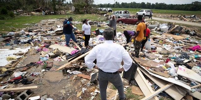 North Carolina Gov. Roy Cooper talks with residents, Wednesday, Aug. 5, 2020, as they looks for personal items in the rubble after a tornado spawned by Hurricane Isaias destroyed a rural mobile home neighborhood killing two residents near Windsor N.C.
