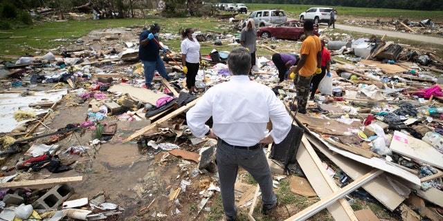 North Carolina Gov. Roy Cooper talks with residents, Wednesday, Aug. 5, 2020, as they looks for personal items in the rubble after a tornado spawned by Hurricane Isaias destroyed a rural mobile home neighborhood killing two residents near Windsor N.C.