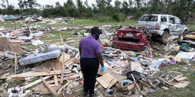 Cynthia Cooper looks for personal items for a family member who had their home destroyed after a tornado spawned by Hurricane Isaias destroyed a rural mobile home neighborhood killing two residents near Windsor N.C. on Wednesday, Aug. 5, 2020.