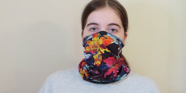 Emma Fischer, study co-author and student at Duke University, dons a neck gaiter. Study co-author Warren S. Warren says this neck gaiter is slightly stretchy and opaque when worn, but single layer and thin enough to see a light through it. (Photo Credit: Martin Fischer, Duke University)
