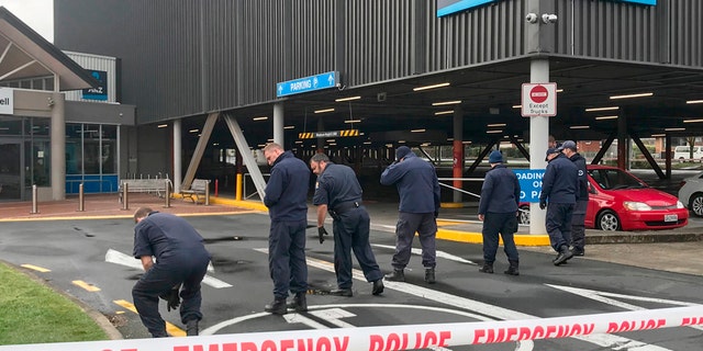 Police search outside the Chartwell Shopping Centre in Hamilton, New Zealand, on Thursday after would-be thieves tried to detonate pipe bombs outside an ATM. (Belinda Feek/NZ Herald via AP)