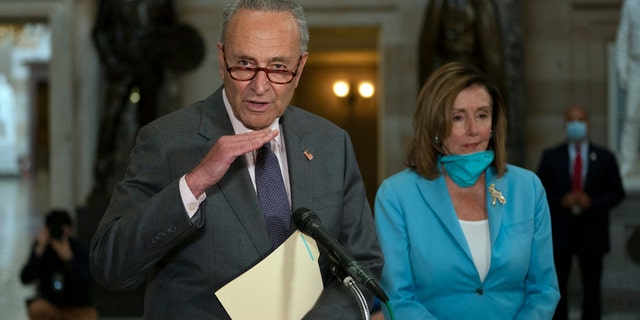 House Speaker Nancy Pelosi of Calif., listens as Senate Minority Leader Sen. Chuck Schumer of N.Y., speaks to media on Capitol Hill in Washington, Wednesday, Aug. 5, 2020.  (AP Photo/Carolyn Kaster)