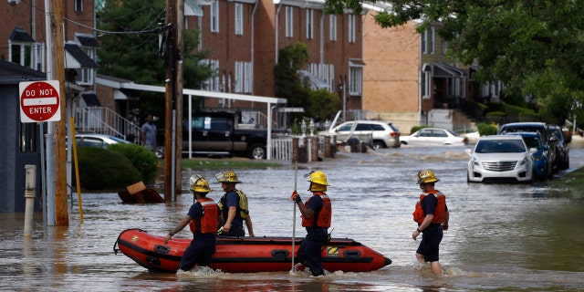 Philadelphia firefighters walk through a flooded neighborhood after Tropical Storm Isaias moved through, Tuesday, Aug. 4, 2020, in Philadelphia.