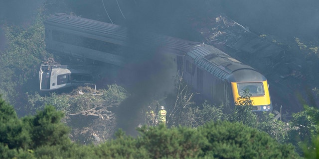 Emergency services personnel are seen at the scene of a train crash near Stonehaven in northeast Scotland on August 12, 2020. (Photo by Michal Wachucik / AFP via Getty Images)