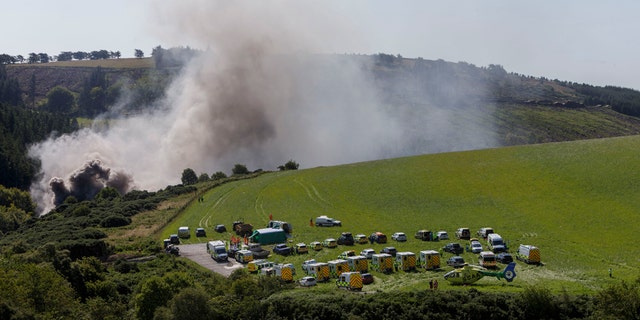 Emergency services attend the scene of a derailed train in Stonehaven, Scotland, Wednesday Aug. 12, 2020. (Ross Johnston/Newsline-media via AP)