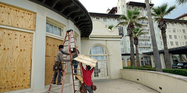 Workers board up windows at the Galvez Hotel & Spa, Tuesday in Galveston, Texas, as Hurricane Laura heads toward the Gulf Coast. (AP Photo/David J. Phillip)