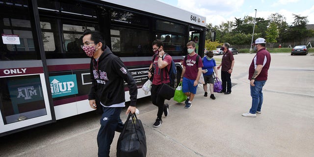 Evacuated students from Texas A&M University at Galveston arrive by bus at Aloft College Station on Tuesday in College Station, Texas. (College Station Eagle via AP)