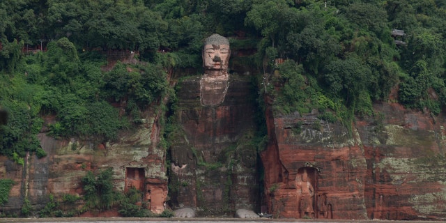 In this photo released by China's Xinhua News Agency, floodwaters flow near the historic Giant Buddha in Leshan in southwestern China's Sichuan Province on Aug. 18, 2020.