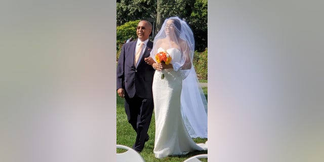 August bride Narolin Cepeda was able to wear her salvaged wedding dress earlier this month after the TSA found her forgotten dress in Newark.  She was escorted down the aisle by her father, Marino.  (Christopher Cepeda)