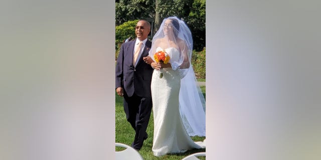 August bride Narolin Cepeda was able to wear her recovered wedding dress earlier this month after the TSA found her forgotten dress in Newark. She was escorted down the aisle by her father, Marino. (Christopher Cepeda)