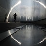 Morning fog shrouds lower Manhattan in New York City as a man runs through the 9/11 Empty Sky Memorial in Jersey City, New Jersey, Aug. 9, 2020.