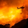 A helicopter drops water on the Lake Hughes fire in Angeles National Forest north of Santa Clarita, California, Aug. 12, 2020. 