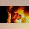 A flag flies over a department of corrections building ablaze during protests sparked by the shooting of Jacob Blake by a police officer in Kenosha, Wis., Aug. 24, 2020. 