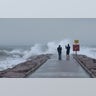 Josue Blanco, left, and Alex Mendez photograph waves generated by Hurricane Laura as they crash into the rock groin at 37th Street in Galveston, Texas on Aug. 26.