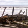 A passerby looks at docks damaged by a storm surge from Hurricane Isaias on North Myrtle Beach in S.C., Tuesday, Aug. 4, 2020.