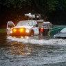 A motorist drives through a flooded intersection during Tropical Storm Isaias, Tuesday, Aug. 4, 2020, in Philadelphia. 