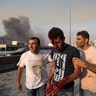 People help a man wounded in a massive explosion in Beirut, Lebanon, Tuesday, Aug. 4, 2020. 