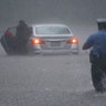 A Philadelphia police officer rushes to help a stranded motorist during Tropical Storm Isaias, in Philadelphia, Aug. 4, 2020. 