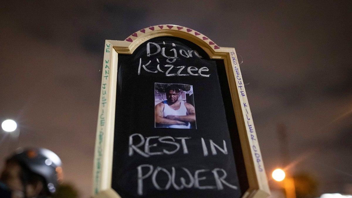 A protester holds a sign with a picture of Dijon Kizzee, a Black man who died after being shot by deputies of the Los Angeles Sheriff's Department on Monday in Los Angeles. (AP Photo/Christian Monterrosa)