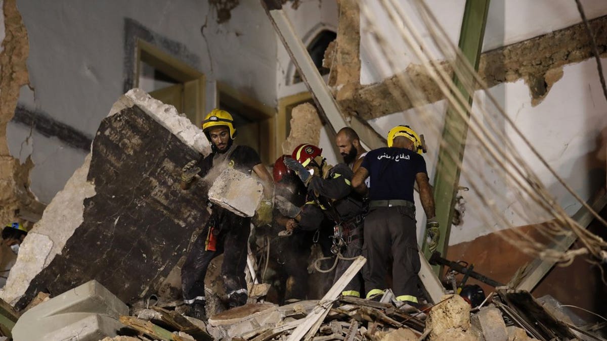 Rescuers search a building that collapsed in last month's massive explosion that hit the seaport of Beirut, after getting signals there may be a survivor under the rubble in Beirut, Lebanon, Early Friday, Sept. 4, 2020. A pulsing signal was detected Thursday from under the rubble of a Beirut building that collapsed during the horrific port explosion in the Lebanese capital last month, raising hopes there may be a survivor still buried there. (AP Photo/Hussein Malla)